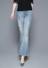 Pantalones acampanados de mezclilla de algodón con apliques de cuentas y cintura alta en color azul claro bohemio